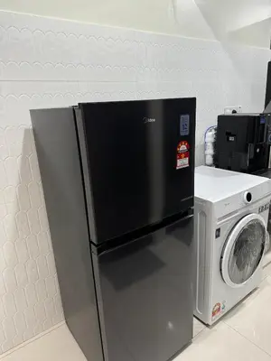 a refrigerator and a washing machine in a kitchen at Namel Homestay Taiping in Kampong Jana