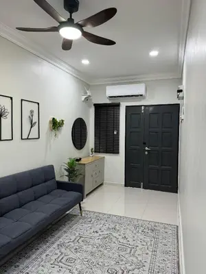 a living room with a couch and a ceiling fan at Namel Homestay Taiping in Kampong Jana