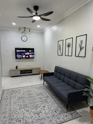 a living room with a couch and a tv at Namel Homestay Taiping in Kampong Jana