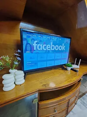a flat screen tv sitting on top of a wooden desk at Busybee Breezy Stay Homestay in Ipoh