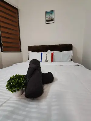 a stuffed animal is laying on a bed at Busybee Breezy Stay Homestay in Ipoh