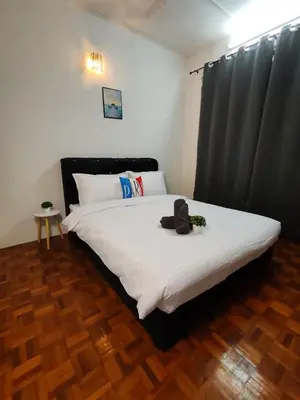 a bedroom with a bed with white sheets and a black curtain at Busybee Breezy Stay Homestay in Ipoh