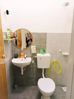 a bathroom with a toilet and a sink and a mirror at Ceq Atiah Homestay in Seri Iskandar