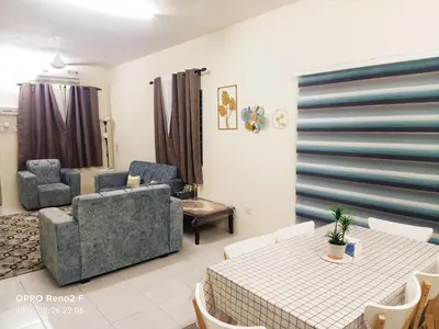 a living room with a couch and a table and chairs at Ceq Atiah Homestay in Seri Iskandar