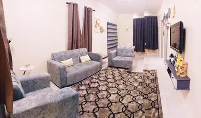 a living room with two chairs and a tv at Ceq Atiah Homestay in Seri Iskandar