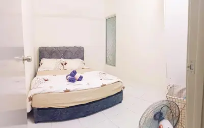 a bedroom with a bed with purple flowers on it at Ceq Atiah Homestay in Seri Iskandar