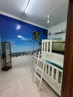 a bedroom with a bed and a view of the beach at Joyhome Homestay in Kampong Lumut Kiri