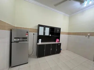 a kitchen with a refrigerator and a stove in it at Joyhome Homestay in Kampong Lumut Kiri