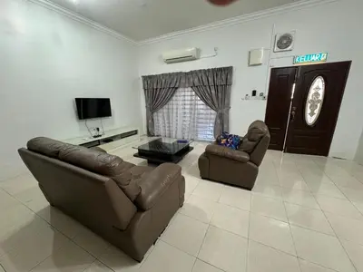 a living room with two couches and a television at Joyhome Homestay in Kampong Lumut Kiri