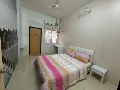 a bedroom with a bed with a striped blanket at Joyhome Homestay in Kampong Lumut Kiri