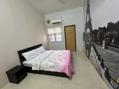 a bedroom with a bed with a pink blanket at Joyhome Homestay in Kampong Lumut Kiri