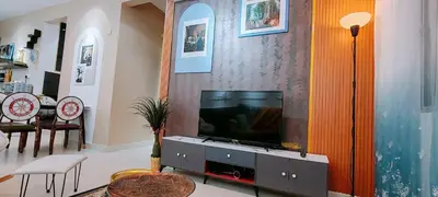 a living room with a flat screen tv on a entertainment center at A boutique Warm falim home in Kampong Pasir Puteh