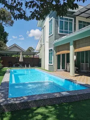 a swimming pool in front of a house at Teratak Dusun NadzYan in Bukit Selambau
