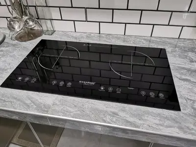 a black stove top oven sitting on top of a counter at Teratak Dusun NadzYan in Bukit Selambau
