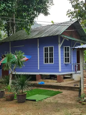 a blue house with plants in front of it at Zue Rra Hidden Retreat in Kampong Kuala Chegar
