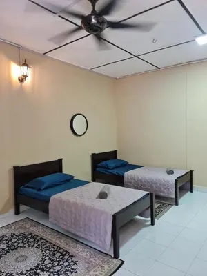 a room with two beds and a ceiling fan at Zue Rra Hidden Retreat in Kampong Kuala Chegar
