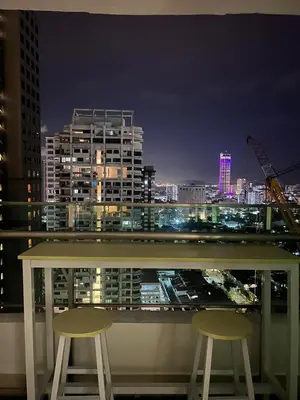 a balcony with two chairs and a city skyline at night at City View & Sea View Mansion One Gleneagles Gurney Komtar George Town by Cozy Cottage Haven in George Town