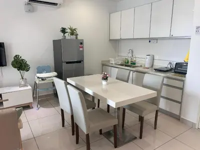 a kitchen with a table and chairs and a refrigerator at City View & Sea View Mansion One Gleneagles Gurney Komtar George Town by Cozy Cottage Haven in George Town