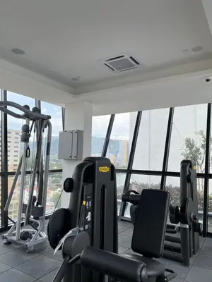 a gym with cardio equipment in a building with windows at Sky High Stuning Penang Bridge & City Views 3BR in Jelutong