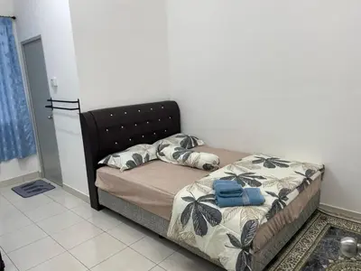 a bedroom with a bed with a black headboard at Amad Homestay in Kuala Lipis