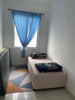 two beds in a room with a window at Amad Homestay in Kuala Lipis