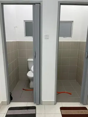 a bathroom with a toilet and a glass door at Amad Homestay in Kuala Lipis
