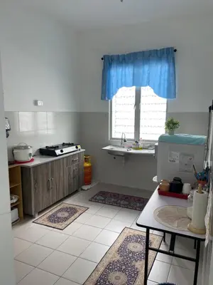 a kitchen with a sink and a window with blue curtains at Amad Homestay in Kuala Lipis