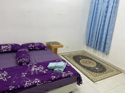 a bedroom with two beds and a blue curtain at Amad Homestay in Kuala Lipis