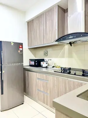 a kitchen with a stainless steel refrigerator and cabinets at Arena guesthouse in Bayan Lepas