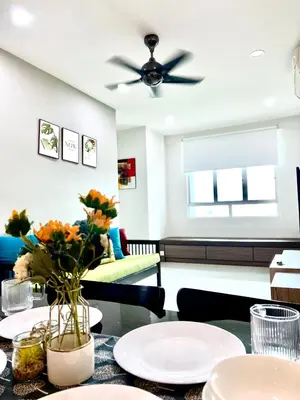 a living room with a table and a ceiling fan at Arena guesthouse in Bayan Lepas