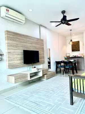 a living room with a flat screen tv on a wall at Arena guesthouse in Bayan Lepas