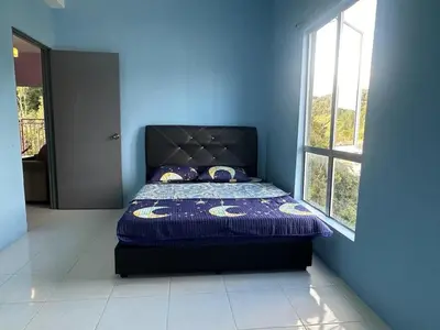 a blue bedroom with a bed in a room with a window at Oh Hanna homestay in Brinchang