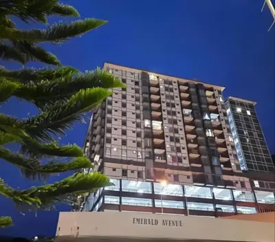 a tall apartment building with a palm tree at Oh Hanna homestay in Brinchang