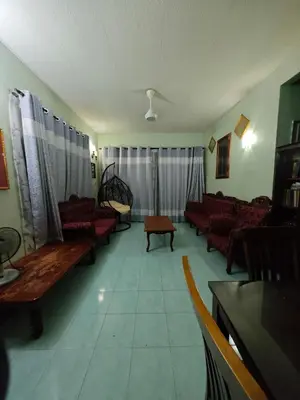 a living room with red couches and a table at Homestay Bendang Becah in Baling