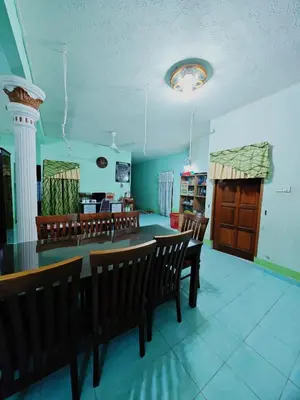 a dining room with a long table and chairs at Homestay Bendang Becah in Baling