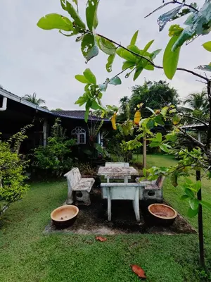 a picnic table and chairs in a yard at Homestay Bendang Becah in Baling