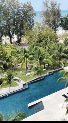 an overhead view of a swimming pool with palm trees at By The Sea Beach Front Sea view Apartment 3 in Batu Ferringhi