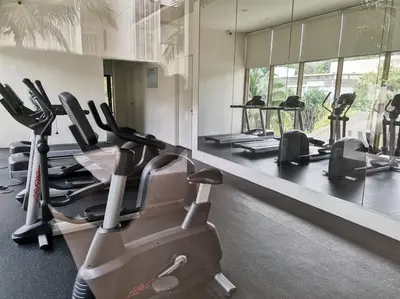 a gym with several treadmills and elliptical machines at By The Sea Beach Front Sea view Apartment 3 in Batu Ferringhi