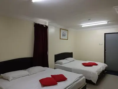 two beds in a room with red pillows on them at Casavilla Hotel in Taiping