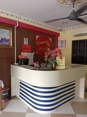 a restaurant with a counter with flowers on it at Casavilla Hotel in Taiping