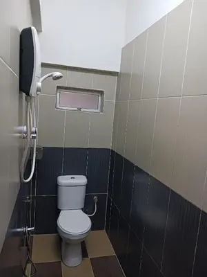 a bathroom with a toilet and a phone at Casavilla Hotel in Taiping