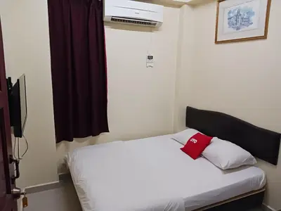 a bedroom with a white bed with a red pillow at Casavilla Hotel in Taiping