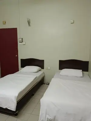 two beds sitting next to each other in a room at Casavilla Hotel in Taiping