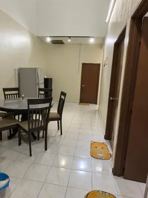a dining room with a table and chairs on the floor at Padang Serai Premier Home in Kampong Dekeh