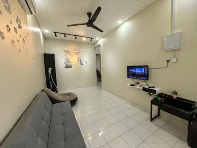 a living room with a couch and a flat screen tv at Padang Serai Premier Home in Kampong Dekeh