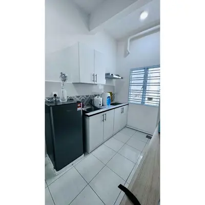 a kitchen with white cabinets and a black refrigerator at Ipoh Anderson Khan Residence by Khan in Ipoh
