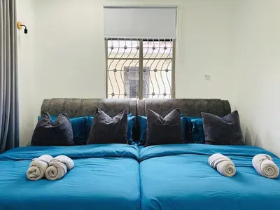 a blue couch with pillows and towels on it at BM\u5927\u5c71\u811a Alma Single Storey Semi-D 5-minute To Aeon Mall in Bukit Mertajam