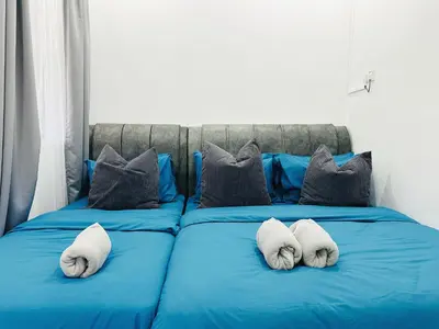 a blue bed with two white pillows on it at BM\u5927\u5c71\u811a Alma Single Storey Semi-D 5-minute To Aeon Mall in Bukit Mertajam