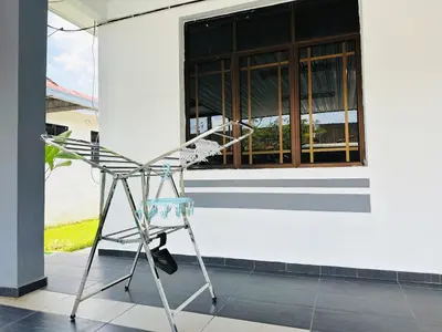 a chair sitting in front of a white building at BM\u5927\u5c71\u811a Alma Single Storey Semi-D 5-minute To Aeon Mall in Bukit Mertajam