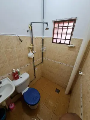 a bathroom with a shower and a toilet and a sink at Azam Homestay in Seri Manjung